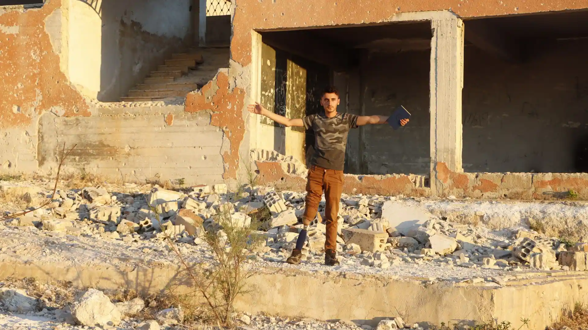 A young man standing among the rubble of a war-torn building, symbolizing the role of peace education in fostering community peace.