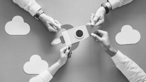 Four hands collaborating to assemble a paper rocket, symbolizing teamwork, innovation and entrepreneurship in launching a startup concept.